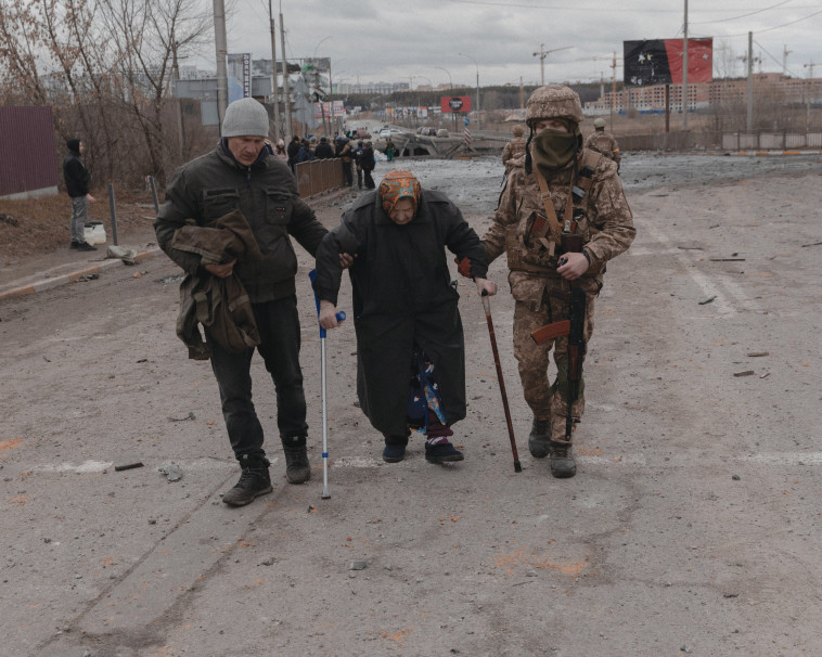 לוחמים באוקראינה עוזרים לאישה מבוגרת (צילום: רויטרס)