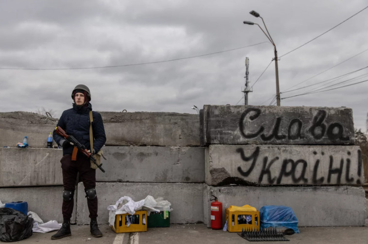 5 במרץ: חבר ביחידת ההגנה הטריטוריאלית עומד בסמוך לחזית הלחימה המזרחית, כשלצידו הכיתוב ''תחי אוקראינה'' (צילום: Chris McGrath/Getty Images)