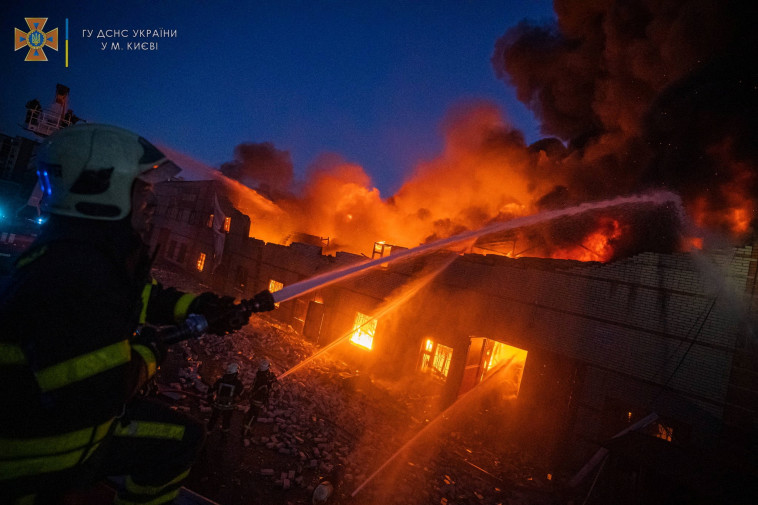 צוות כיבוי אש משתלט על שריפה שנגרמה מהפגזה על העיר קייב (צילום: רויטרס)