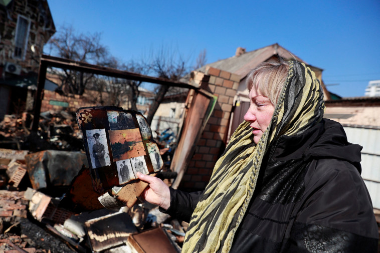 23 במרץ: נטליה, מורה לשעבר, מוצאת פיסות מחפציה בין ההריסות אחרי המתקפה האווירית על קייב (צילום: REUTERS/Serhii Nuzhnenko)