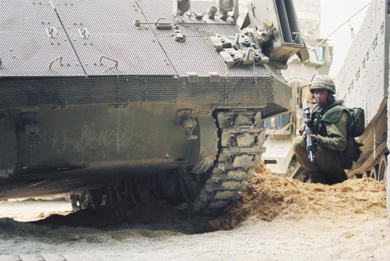 חייל צה''ל לצד נגמ''ש במבצע ''חומת מגן'', 2002 (צילום: דובר צה''ל)