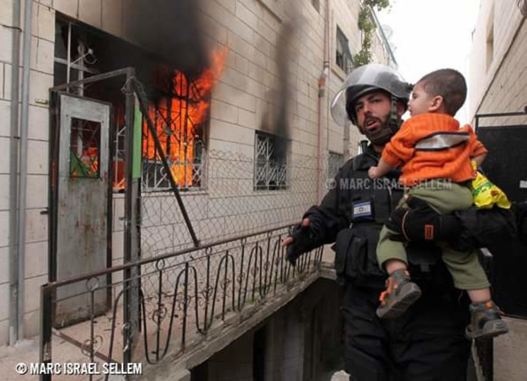 כוחות הביטחון מחלצים את המשפחה שנלכדה באש (צילום: מארק ישראל סלם)