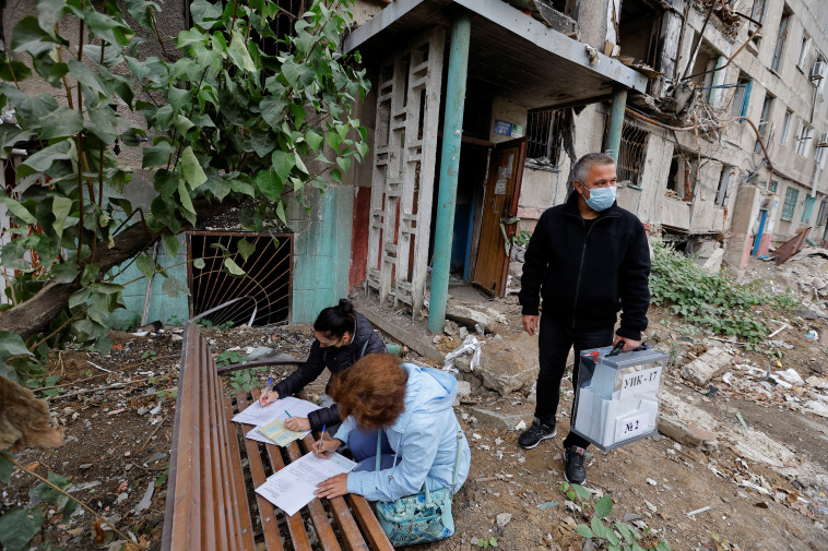 אזרחים מקומיים במריופול ממלאים פתקי הצבעה במשאל העם הכפוי  (צילום: REUTERS/Alexander Ermochenko )