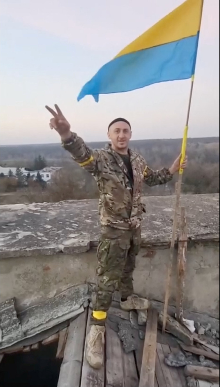  חיילים אוקראינים מניפים את דגל אוקראינה בחרסון לאחר שחרורה (צילום: רויטרס)