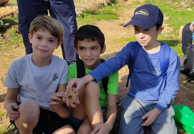 שלושת הילדים אלון כהן, ליאם אטיאס ורותם לבנת מחזיקים בנר שמצאו  (צילום: שלומית אלימור)