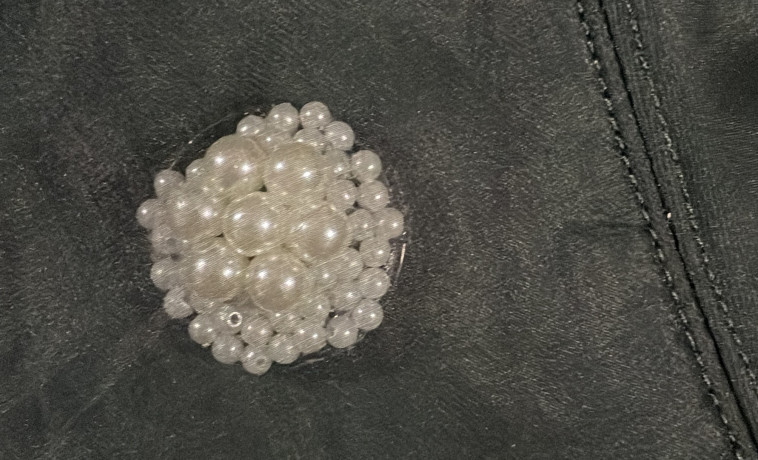 לחצן המצוקה Safe Button מעוטר בפנינים ומוסווה על הבגד