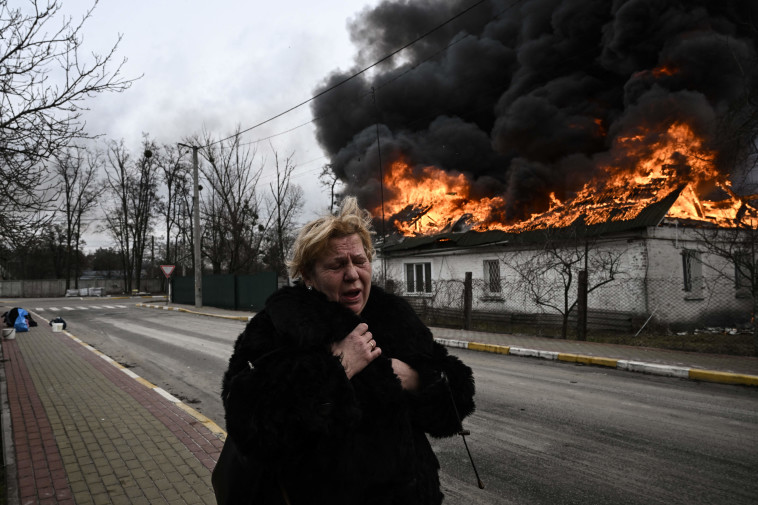 אישה בורחת מהפצצות באוקראינה  (צילום: ARIS MESSINIS.GettyImages)