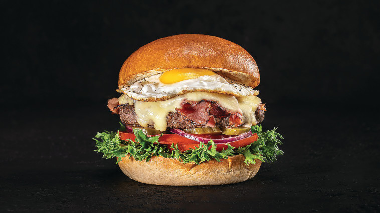 המבורגר מושחת מבקר הולשטיין מובחר בתוספת אקסטרה קורנביף ביצת עין גבינת . גאודה עם ירקות. 