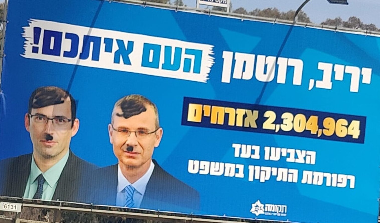 השלט שהושחת עם פניהם של לוין ורוטמן (צילום: אתר חדשות 0404)