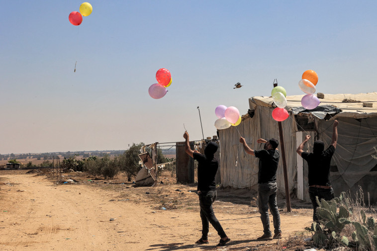 עזתים מפריחים בלוני תבערה לכיוון ישראל (צילום: AFP via Getty Images)