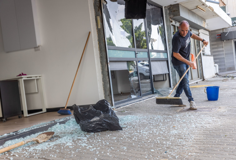 אחרי הטיל, בעל החנות אוסף את השברים. 