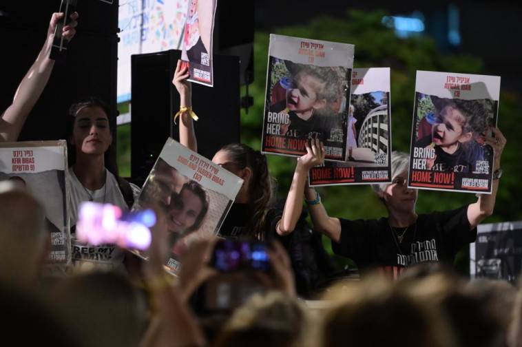 משפחות החטופים בעצרת בתל אביב, מניפים את תמונות הילדים