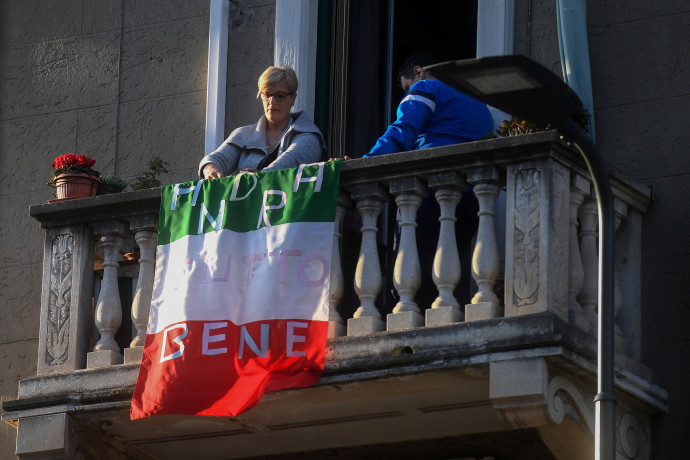 קורונה באיטליה: אישה מניחה את דגל איטליה עם הכיתוב: 